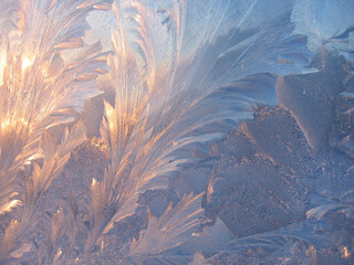 Ice pattern and sunlight on window glass early in the morning
