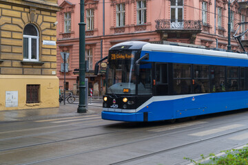 Fototapeta premium Krakow, Poland December 17, 2021; Blue tram on the streets of Krakow.