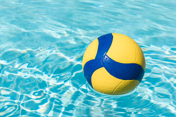 Sports ball on the surface of swimming pool's water, water volleyball.