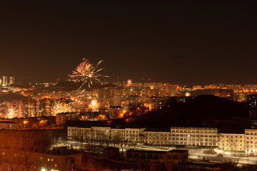 Naklejka premium Fireworks in the city at night during New Year celebration. Soft focus background