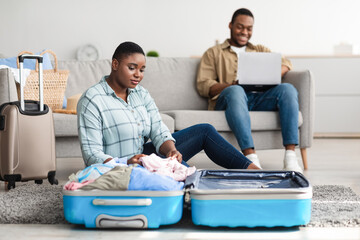 Black Family Packing Suitcase And Booking Tickets For Travel Indoors