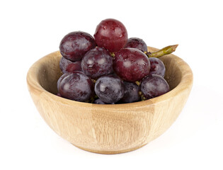 Grapes on wooden bowl isolated on white background front view.