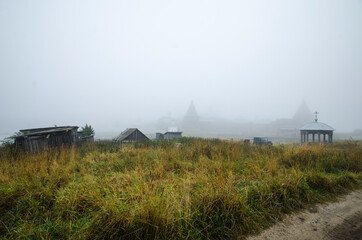 Fototapeta na wymiar View of the Solovetsky Monastery in the fog. Fortress over water 