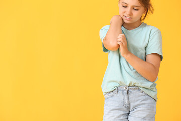 Little girl scratching herself on color background