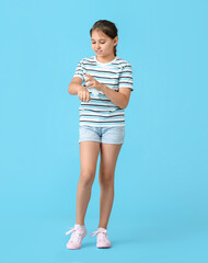 Little girl with mosquito repellent on color background