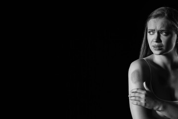 Fototapeta premium Scared woman with bruises on dark background. Violence concept