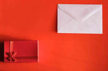 Concept for valentine's day. A envelope with Valentine card and a gift on a red background with...