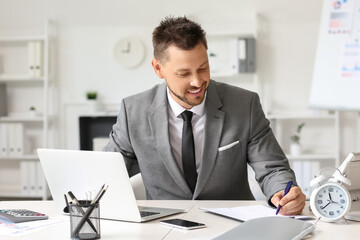 Smiling businessman working at table in office