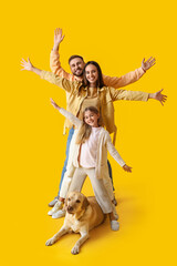 Happy parents with little daughter and cute Labrador dog on yellow background