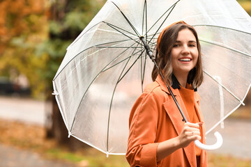 Portrait of happy woman with umbrella on city street - obrazy, fototapety, plakaty