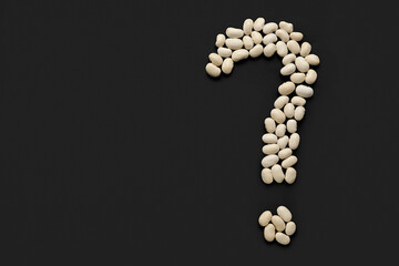 Question mark made of white beans on black background