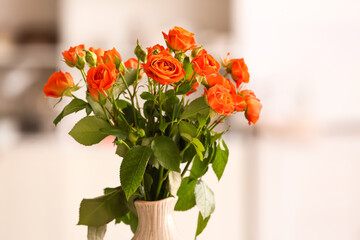 Vase with beautiful orange roses in room, closeup