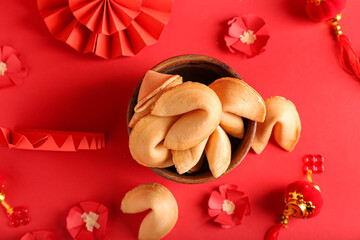 Bowl with tasty fortune cookies and Chinese symbols on color background
