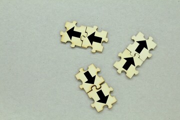 Wooden puzzles with arrows one in different direction and the other in different directions
