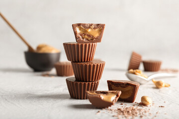 Tasty peanut butter cups on light background
