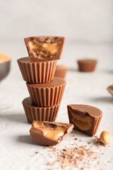 Tasty peanut butter cups on light background