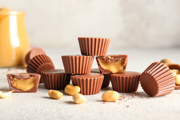 Tasty peanut butter cups on light background
