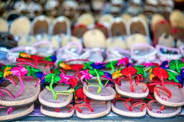 Colorful slippers in a shop. Tropical shoes.