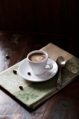 Cup of coffee on rustic wooden background.