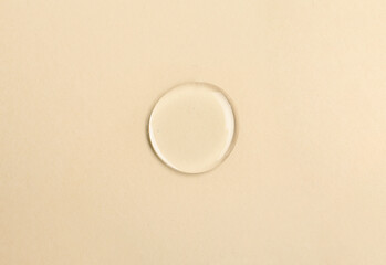 Round drop of liquid transparent gel on color background