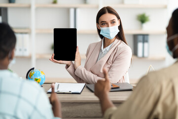 Tour Agent Showing Tablet Screen To Tourists Offering Vacation Indoor
