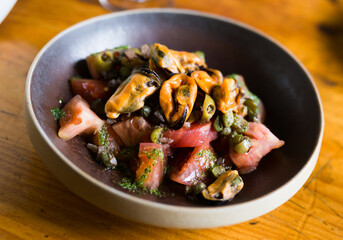 Tomatoes with arugula pesto, mussels, olives and capers