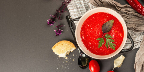 Vegan food, spicy tomato gazpacho soup with toasts, ripe vegetables, and fresh basil herbs
