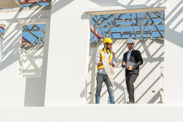 Project Manager Check the construction progress and the strength with Foreman standing on the balcony of the house while the roof is being built. 