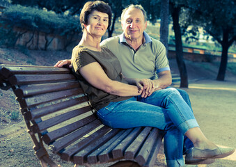 elderly man and woman embracing on bench