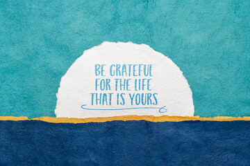 Be grateful for the life that is yours - inspirational reminder or advice, handwriting on watercolor paper against abstract landscape, gratitude and personal development concept