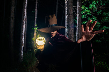 Young sorcerer demonstrating magic in the forest
