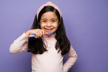 Healthy kid happy brushing her teeth