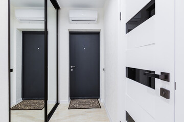 Corridor interior with white doors in a small studio apartment