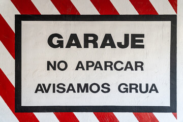 Garage sign, no parking, tow truck warning, painted on the wall at the entrance of a garage