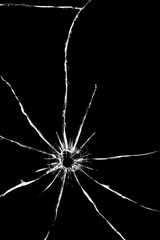 Hole from a shot with a weapon in the glass. Cracks on the back of the car. Texture on a black background, the effect of broken windshield.