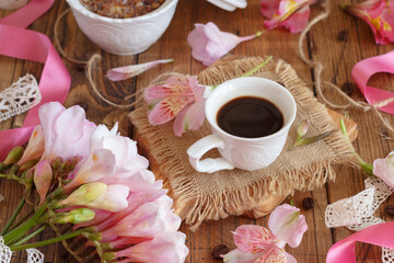 Breakfast with coffee and flowers close up on wooden table