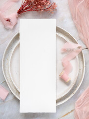 Blank card on a plate with pink flowers and ribbons