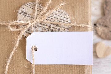 Valentines present with blank gift tag near hearts top view, Rustic label Mockup