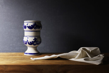 Natura morta con vaso bianco e blu in ceramica isolato su fondo scuro