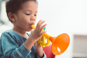 Baby plaing trumpet toy - obrazy, fototapety, plakaty