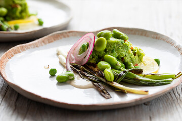 Grilled spring onions with tahini sauce, broad beans salasa and pickled onions