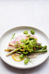 Grilled spring onions with tahini sauce, broad beans salasa and pickled onions