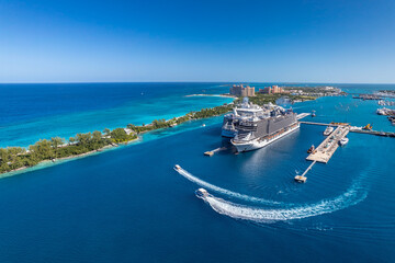 The drone aerial view of cruise ships in the clear blue Caribbean ocean docked in the port of...