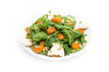 Vegetable salad with pumpkin, arugula and blue cheese on a white background