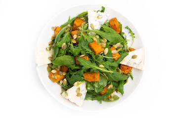 Vegetable salad with pumpkin, arugula and blue cheese in a plate on a white background