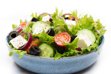 Greek salad with feta, olives, tomatoes and cucumbers isolated on a white background