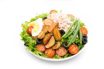 A plate of nicoise salad with tuna and potatoes isolated on a white background