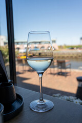 Glass of white wine served in cafe with view on harbour of Harlingen, vacation in Friesland, Netherlands
