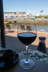 Glass of red wine served in cafe with view on harbour of Harlingen, vacation in Friesland, Netherlands
