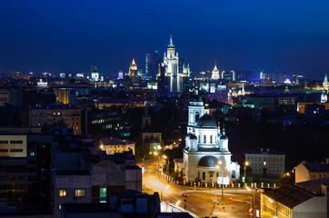 Deep blue saturated night sky with nightlights in the city panorama. Illuminated buildings and Silhouette of town. Moscow